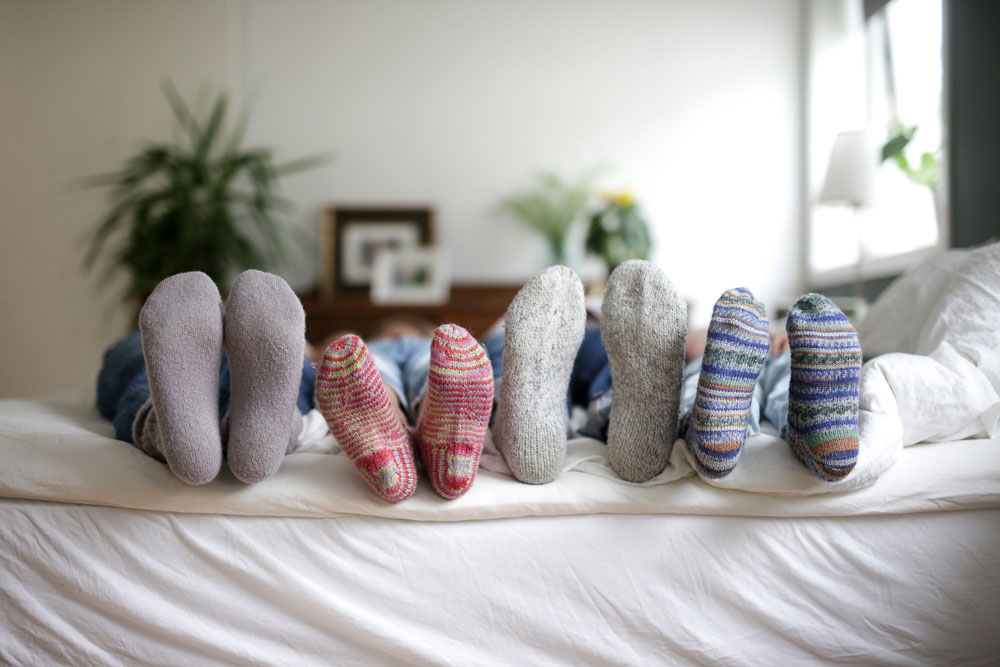 Fire mennesker med raggsokker på føttene